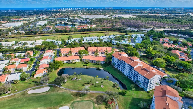 drone / aerial view with golf course view and a water view