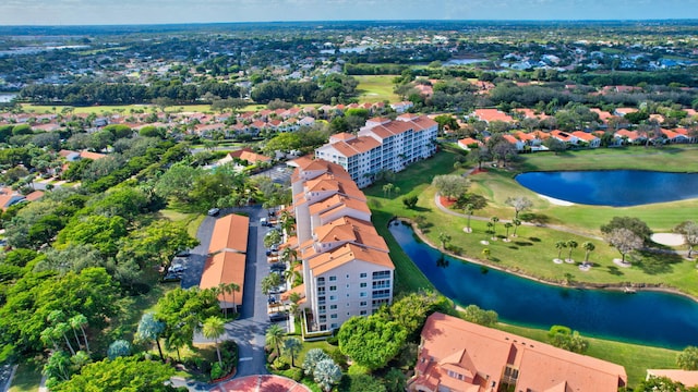 birds eye view of property with view of golf course and a water view