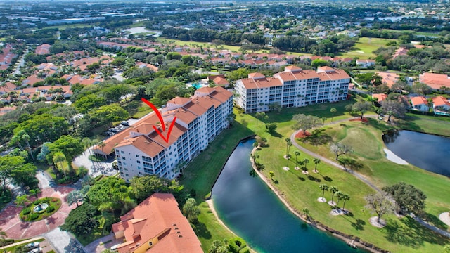 birds eye view of property with golf course view and a water view