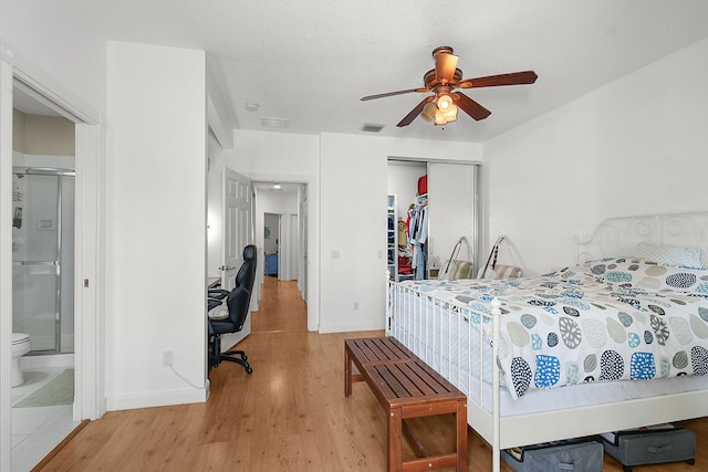 bedroom featuring connected bathroom, ceiling fan, a closet, and light wood-type flooring