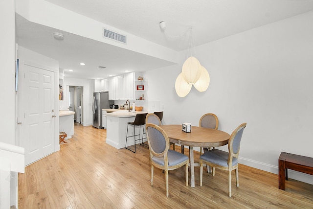 dining room with light hardwood / wood-style floors and sink