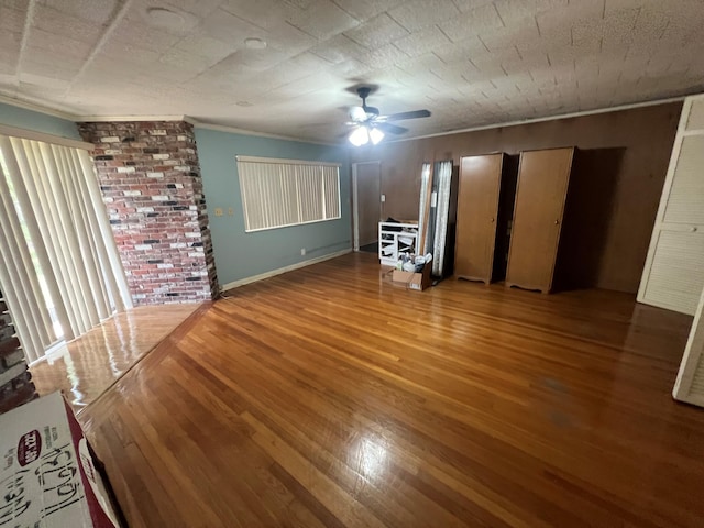 unfurnished living room featuring ceiling fan, wood-type flooring, and ornamental molding