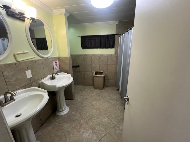 bathroom with dual sinks, tile walls, and ornamental molding