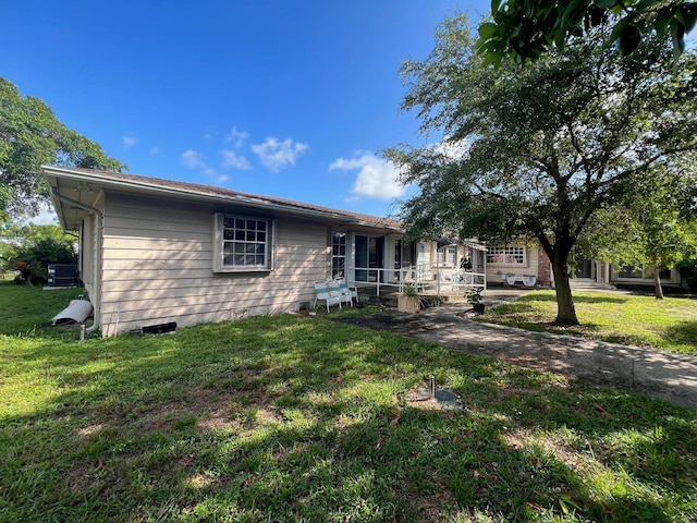 rear view of property featuring a yard and central AC unit