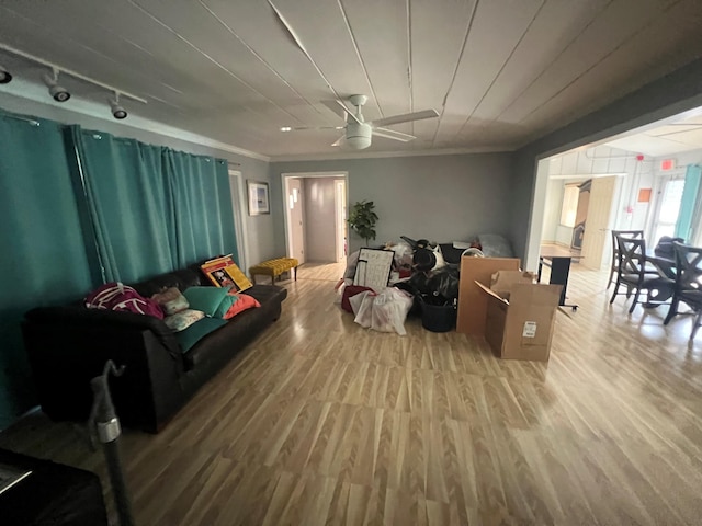 living room featuring hardwood / wood-style flooring, ceiling fan, and ornamental molding