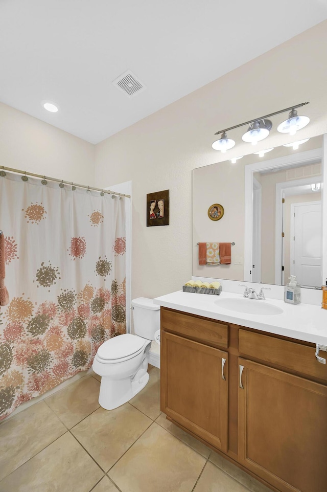 bathroom with toilet, tile patterned floors, and vanity