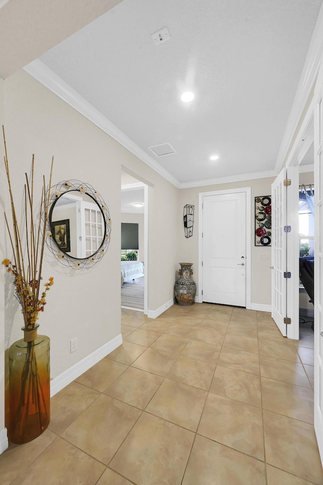 entrance foyer with light tile patterned flooring and crown molding