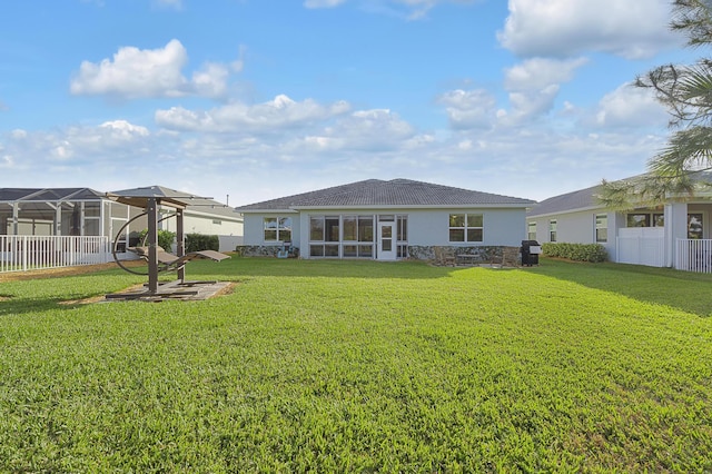 rear view of property featuring a lawn