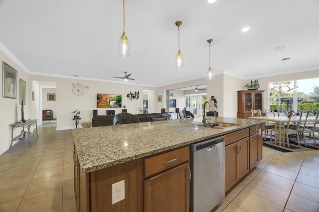 kitchen featuring ceiling fan, stainless steel dishwasher, sink, hanging light fixtures, and a kitchen island with sink