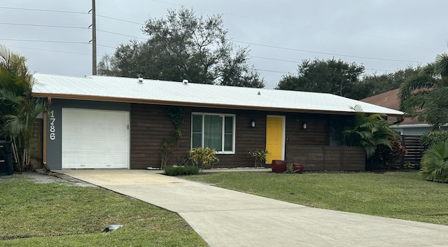 ranch-style house featuring a garage and a front lawn