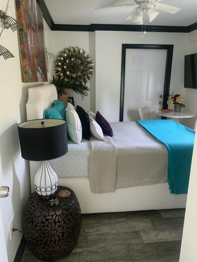 bedroom with ceiling fan, crown molding, and dark wood-type flooring