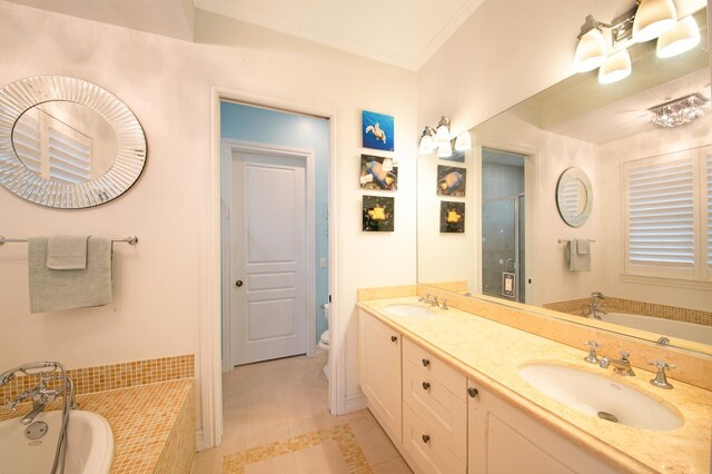 bathroom featuring ornamental molding, vanity, tile patterned flooring, and tiled tub