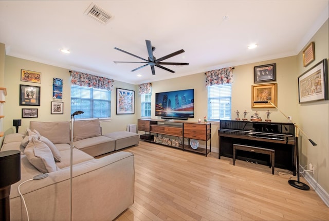 living room featuring ornamental molding, ceiling fan, and light wood-type flooring