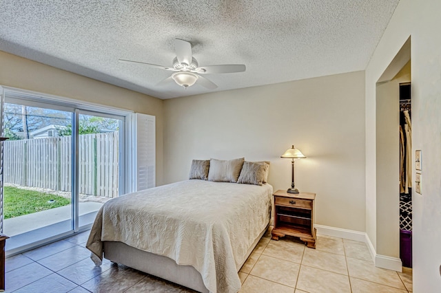 tiled bedroom with ceiling fan, access to exterior, a textured ceiling, and a closet