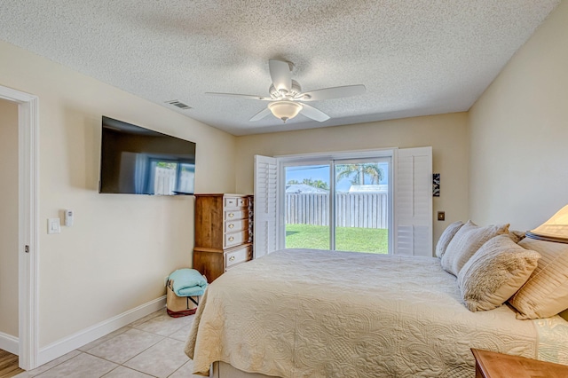 tiled bedroom with a textured ceiling, access to outside, and ceiling fan