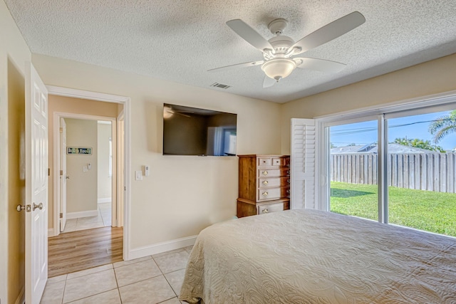 bedroom with access to outside, multiple windows, ceiling fan, and light tile patterned floors