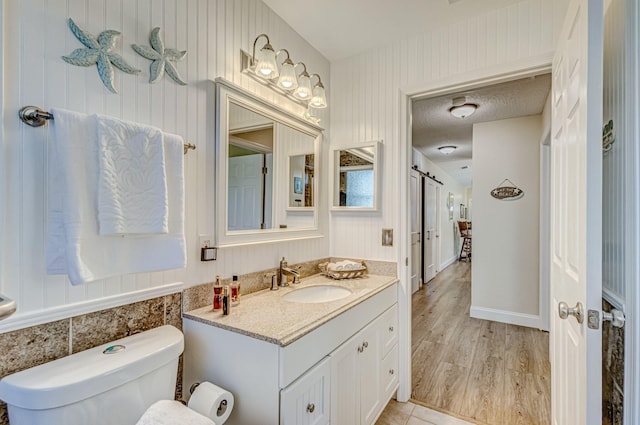 bathroom featuring hardwood / wood-style floors, vanity, a textured ceiling, and toilet