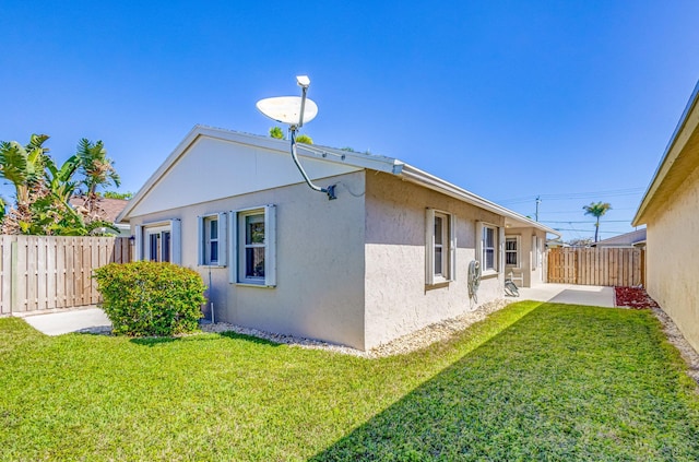 view of property exterior featuring a lawn and a patio