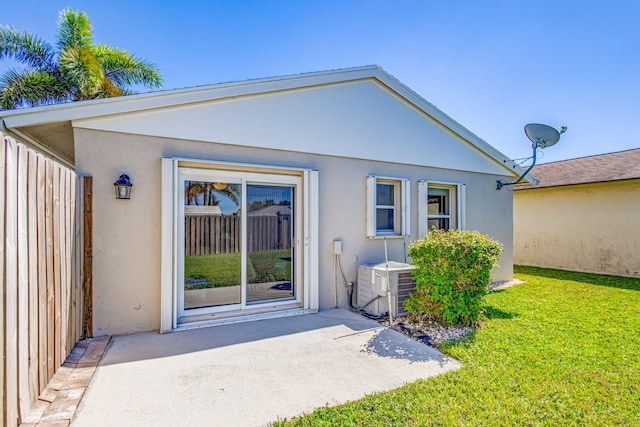 back of property featuring a lawn, a patio area, and central AC