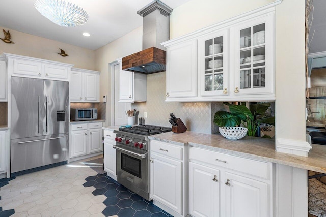 kitchen with premium range hood, backsplash, white cabinetry, and stainless steel appliances