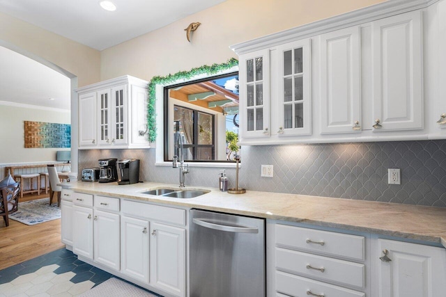 kitchen with stainless steel dishwasher, light tile patterned flooring, white cabinetry, and sink