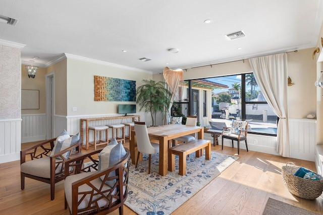 dining room with light hardwood / wood-style floors and ornamental molding