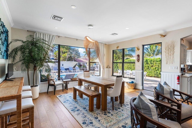 dining room featuring light hardwood / wood-style flooring and ornamental molding