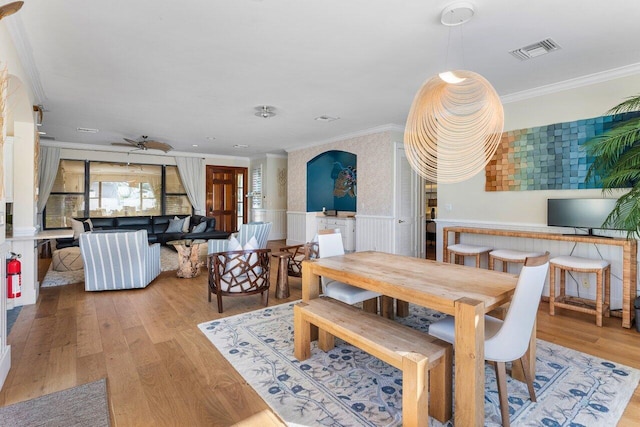 dining room featuring crown molding, ceiling fan, and light wood-type flooring