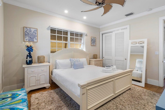 bedroom featuring wood-type flooring, a closet, ornamental molding, and ceiling fan