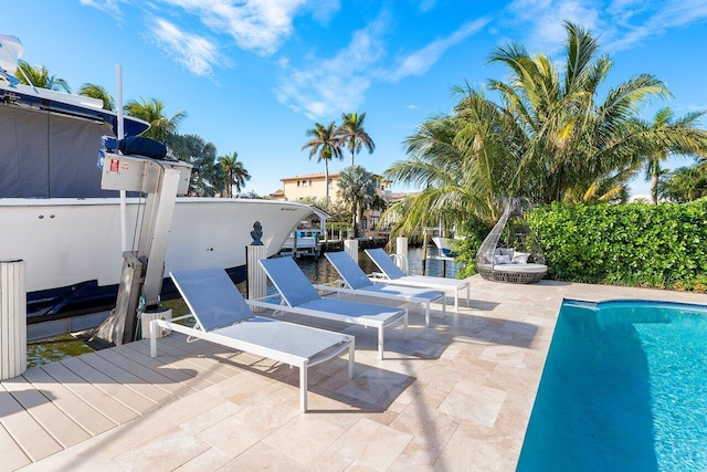 view of swimming pool with a dock and a patio