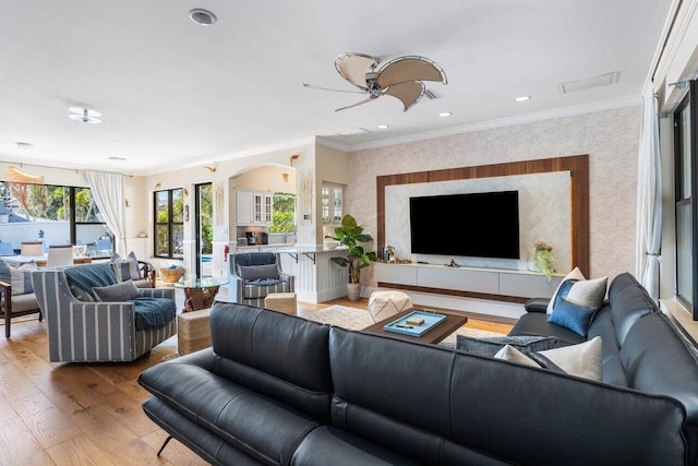 living room featuring hardwood / wood-style flooring, ceiling fan, and ornamental molding