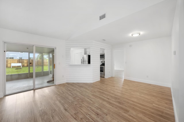 unfurnished living room with lofted ceiling and light hardwood / wood-style flooring