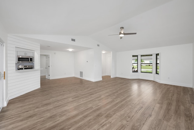 unfurnished living room with hardwood / wood-style floors, vaulted ceiling, and ceiling fan