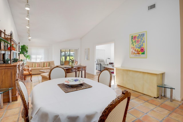 tiled dining space featuring lofted ceiling