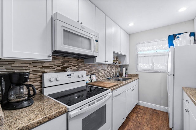 kitchen with tasteful backsplash, dark stone counters, white appliances, sink, and white cabinets