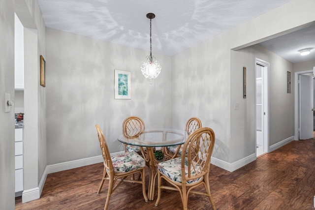 dining space with a textured ceiling and dark hardwood / wood-style floors