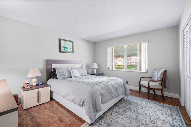 bedroom featuring wood-type flooring, a textured ceiling, and a closet