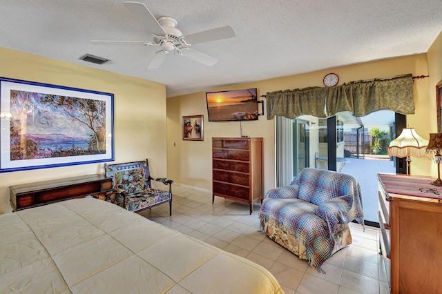 bedroom with ceiling fan, a textured ceiling, and light tile patterned floors