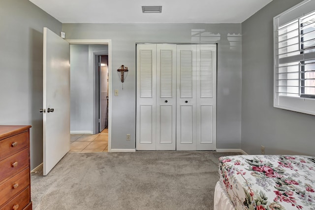 bedroom with light carpet and a closet