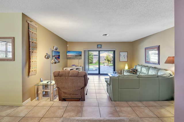 living room with a textured ceiling and light tile patterned flooring