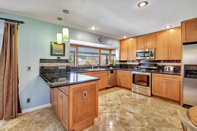 kitchen featuring sink, decorative light fixtures, appliances with stainless steel finishes, kitchen peninsula, and decorative backsplash