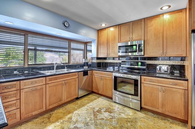 kitchen with tasteful backsplash, appliances with stainless steel finishes, and sink