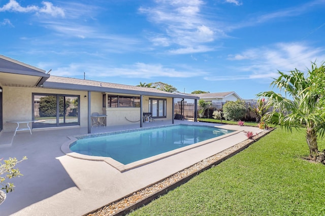 view of pool with a patio area and a lawn