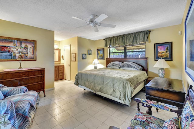 bedroom featuring ceiling fan, ensuite bath, a textured ceiling, and light tile patterned floors