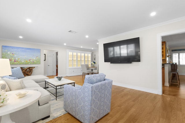 living room featuring light hardwood / wood-style floors and crown molding