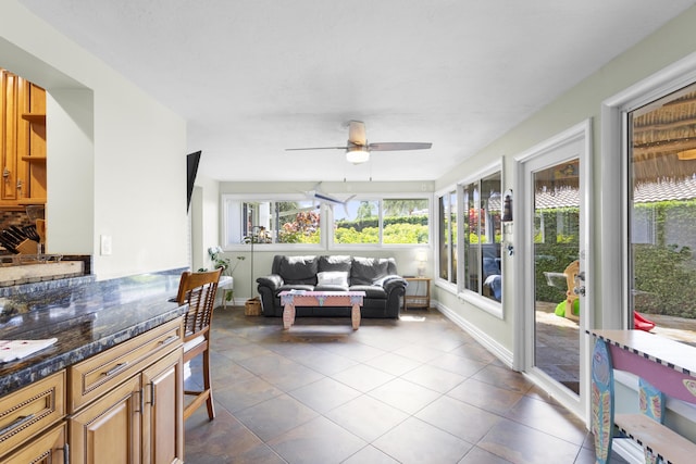 sunroom / solarium featuring ceiling fan