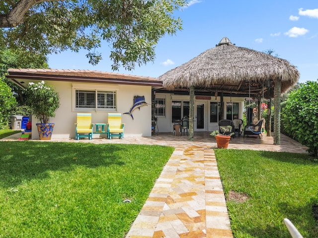 back of house with a lawn and a patio