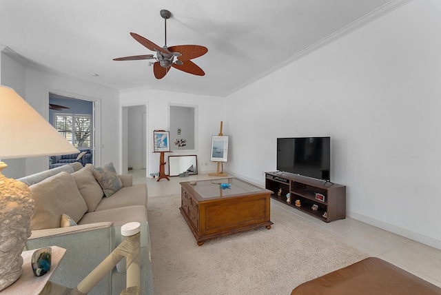 tiled living room with ceiling fan and crown molding