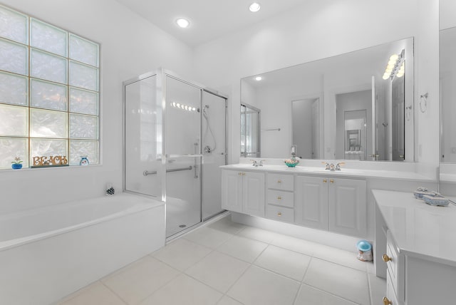 bathroom with plus walk in shower, vanity, and tile patterned flooring