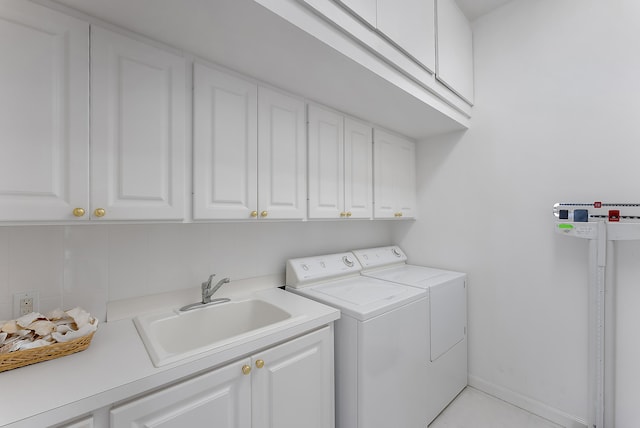 laundry room featuring cabinets, washing machine and clothes dryer, and sink